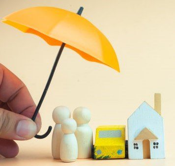 Umbrella covering a miniature house and figures